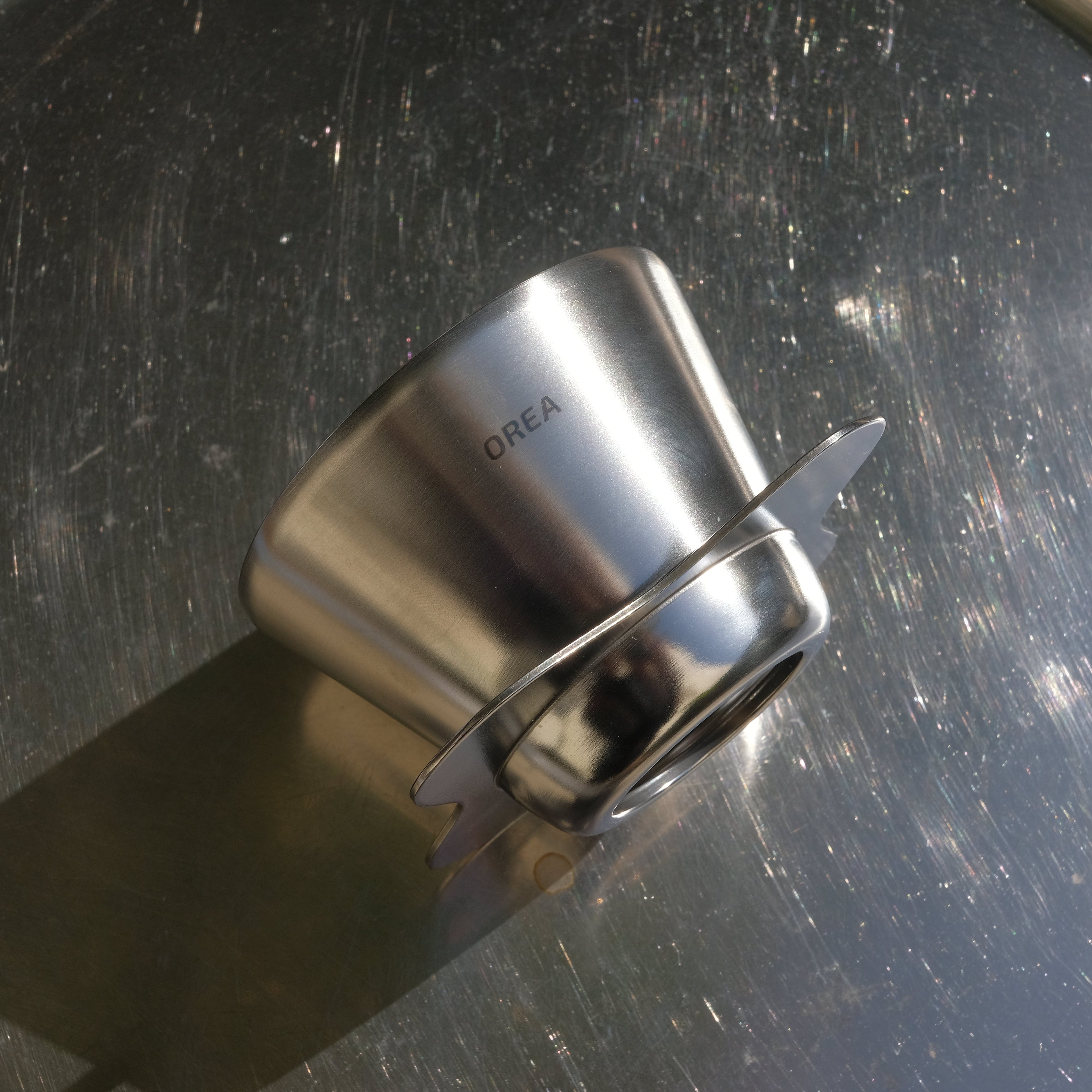 Metallic coffee filter on a metallic surface
