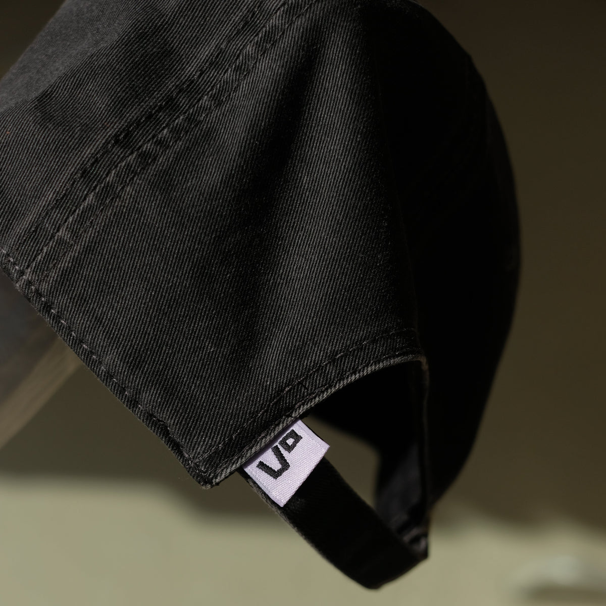 Black cap with a visible brand logo on a blurred background